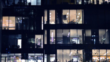 Fragment Of The Glass Facade Of A Modern Corporate Building At Night. Modern Glass Office  In City. 