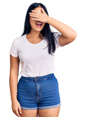 Wall Mural - Young beautiful asian girl wearing casual clothes and glasses smiling and laughing with hand on face covering eyes for surprise. blind concept.