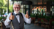 © Kordiush - Portrait of senior man with beard and mustache showing thumbs up in cafe