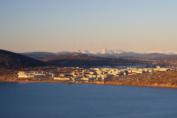 Wall Mural - View of the Nagaev bay and the city of Magadan. Northern port city on the coast of the Sea of Okhotsk. Mountains in the distance. Sunset. Travel and tourism in the Magadan region. Far East of Russia.