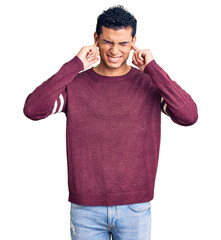 Sticker - Hispanic handsome young man wearing casual clothes covering ears with fingers with annoyed expression for the noise of loud music. deaf concept.