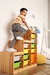 Poster - Little Asian boy having fun in bedroom