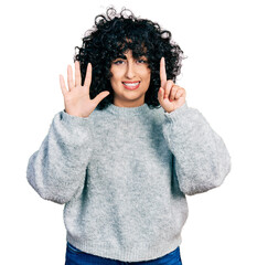 Sticker - Young middle east girl wearing casual clothes showing and pointing up with fingers number six while smiling confident and happy.