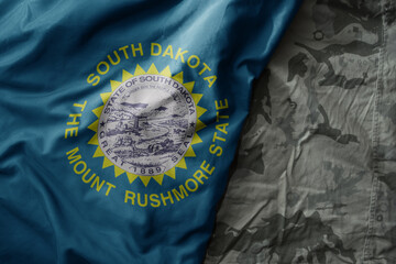 Wall Mural - waving flag of south dakota state on the old khaki texture background. military concept.