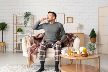 Poster - Sick young man using nasal drops at home