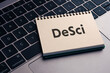 There is notebook with the word DeSci. It is an abbreviation for DeSci as eye-catching image.
