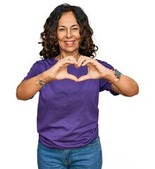 Wall Mural - Middle age hispanic woman wearing casual clothes smiling in love doing heart symbol shape with hands. romantic concept.