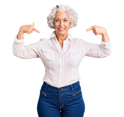 Wall Mural - Senior grey-haired woman wearing casual clothes looking confident with smile on face, pointing oneself with fingers proud and happy.
