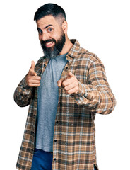 Wall Mural - Hispanic man with beard wearing casual shirt pointing fingers to camera with happy and funny face. good energy and vibes.