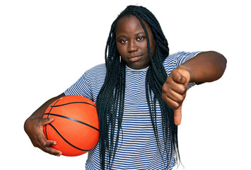 Sticker - Young black woman with braids holding basketball ball with angry face, negative sign showing dislike with thumbs down, rejection concept