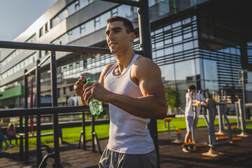 man young male athlete hold bottle of water drink training outdoor