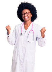 Poster - Young african american woman wearing doctor coat and stethoscope very happy and excited doing winner gesture with arms raised, smiling and screaming for success. celebration concept.