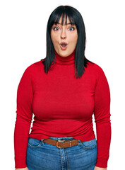 Canvas Print - Young hispanic woman wearing casual clothes afraid and shocked with surprise expression, fear and excited face.