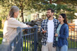 © New Africa - Friendly relationship with neighbours. Happy young couple talking to senior woman near fence outdoors