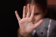 Child abuse. Little girl doing stop gesture on dark background, selective focus
