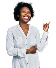 Canvas Print - African american woman with afro hair wearing casual white t shirt with a big smile on face, pointing with hand and finger to the side looking at the camera.