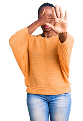 Poster - Young african american woman wearing casual clothes covering eyes with hands and doing stop gesture with sad and fear expression. embarrassed and negative concept.