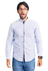 Poster - Handsome hispanic man wearing business shirt and glasses in shock face, looking skeptical and sarcastic, surprised with open mouth