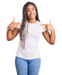 © Krakenimages.com - Young african american woman with braids wearing casual clothes looking confident with smile on face, pointing oneself with fingers proud and happy.