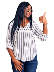 Sticker - Young african american woman wearing casual clothes and glasses looking proud, smiling doing thumbs up gesture to the side