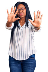 Poster - Young african american woman wearing casual clothes and glasses doing stop gesture with hands palms, angry and frustration expression