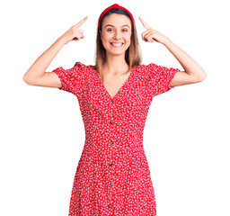 Wall Mural - Young beautiful girl wearing dress and diadem smiling pointing to head with both hands finger, great idea or thought, good memory