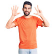 © Krakenimages.com - Young handsome man with beard wearing casual t-shirt showing and pointing up with fingers number eight while smiling confident and happy.