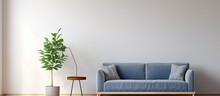 Simple living room interior with a blue sofa, grey lamp, wooden table, ficus, and ladder.