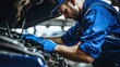 © Moon Story - Male mechanic is repairing a car in an auto repair shop.
