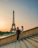 Fototapeta Paryż - Young couple by Eiffel Tower at Sunrise Paris Eifel Towe, man woman in love valentine concept in Paris the city of love. Men and women visiting the Eiffel Tower honeymoon trip