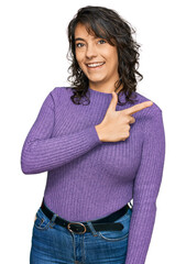 Wall Mural - Young hispanic woman wearing casual clothes cheerful with a smile of face pointing with hand and finger up to the side with happy and natural expression on face