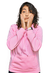Wall Mural - Young hispanic woman wearing casual sweatshirt tired hands covering face, depression and sadness, upset and irritated for problem