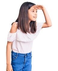 Poster - Beautiful child girl wearing casual clothes very happy and smiling looking far away with hand over head. searching concept.