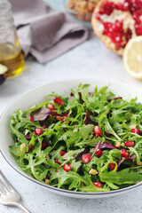 Wall Mural - A plate with green rocket salad with pomegranate and avocado