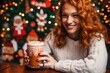 woman sipping a gingerbread latte next to holiday decorations