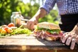 man rustic sandwich loaf on picnic table for a meal