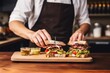 © primopiano - male barista serving a sandwich with pickles on a wooden plate