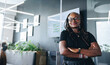 © Jacob Lund - African business woman stands outside a conference room with crossed arms