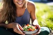 © primopiano - close perspective of a woman enjoying a burrito bowl outdoors