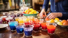 Person Preparing Fruit With Colorful Drinks On A Table.