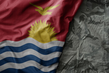 Wall Mural - waving flag of Kiribati on the old khaki texture background. military concept.