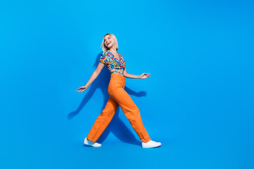 Sticker - Full body profile photo of stunning cheerful lady walk look back empty space isolated on blue color background