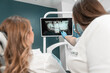 © YURIMA - The dentist carefully analyzes the MRI image of the oral cavity in order to plan treatment. The patient receives an individual consultation from an experienced dentist based on the analysis of images.