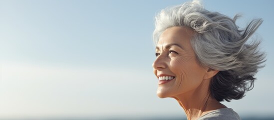 Wall Mural - Middle age grey haired woman smiling confident relaxed with hands on head at seaside. Website header. Creative Banner. Copyspace image