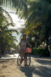 Kobieta na rowerze pod palmami