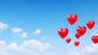 Heart-shaped balloons floating against a clear blue sky.