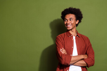 Photo portrait of nice young man crossed hands look cheerful empty space dressed stylish brown garment isolated on khaki color background