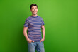 © deagreez - Photo of positive intelligent young man beaming smile put arms pockets look empty space isolated on green color background
