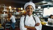 Portrait of a happy beautiful smiling female chef with hands crossed in the kitchen