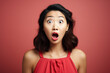 A charming Asian woman with a surprised expression has an unexpected expression of surprise on her face against a lively studio background.